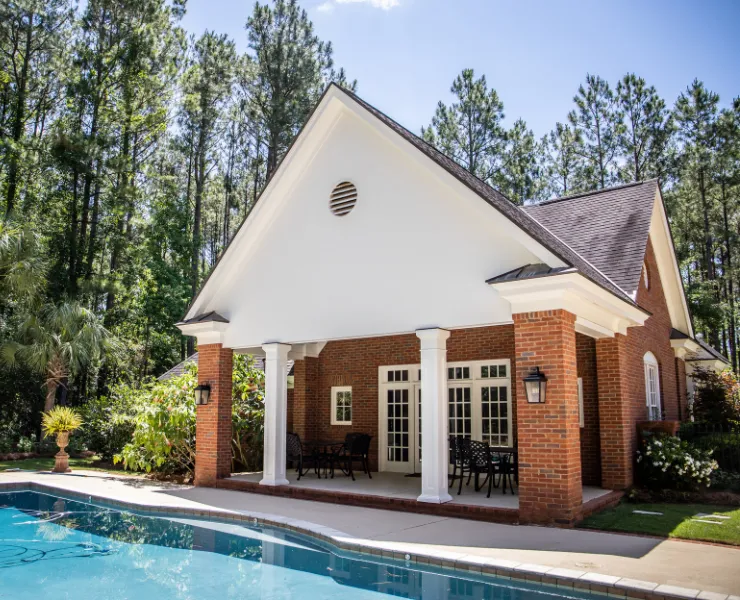 Pool house ADU Dallas TX project featuring luxury backyard poolside suite with covered patio brick columns and private guest living space