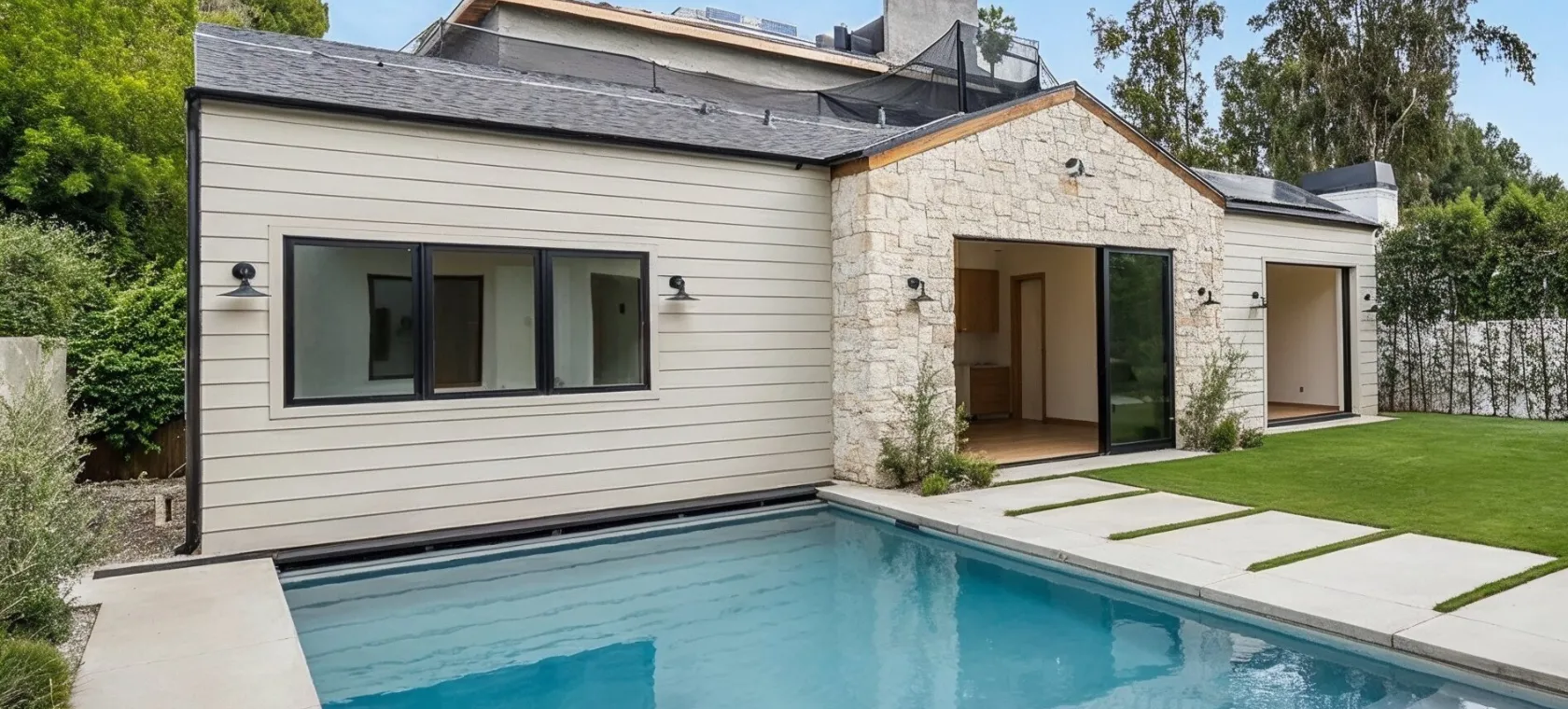 After backyard guest house builders Dallas TX project showing completed poolside guest suite with private entrance patio and outdoor living area